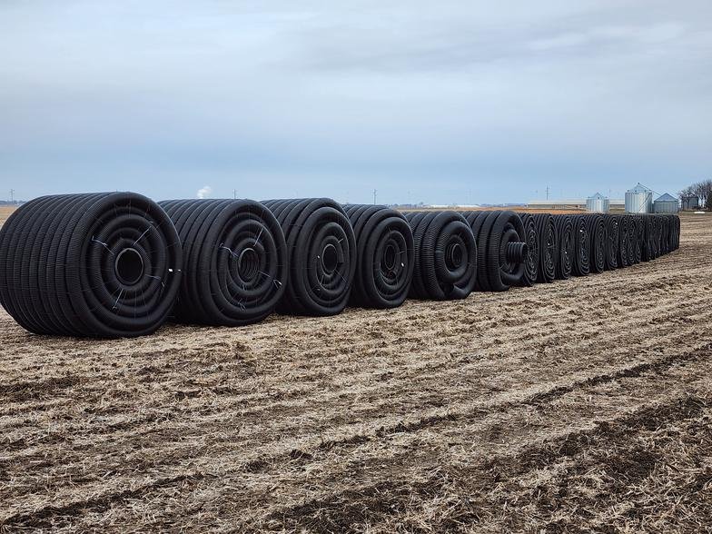 Rolls of drainage tile staged for a farm field near Storm Lake, Iowa